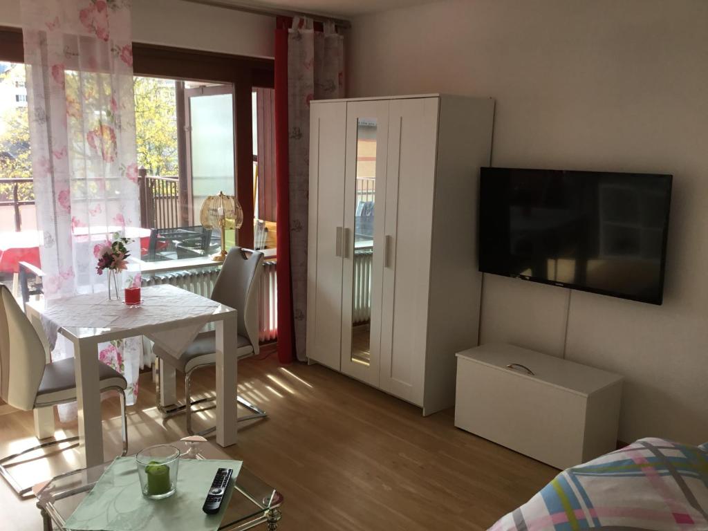 ein Wohnzimmer mit einem Tisch und einem TV in der Unterkunft 1Z.FeWo 236 barbo Schwimmbad,Sauna,Fitness in Schönwald