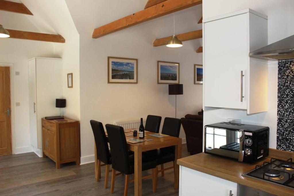 a kitchen and living room with a table and chairs at Greenacres in Kelsale