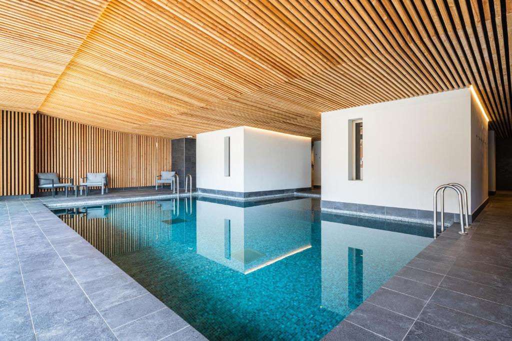 une grande piscine avec un plafond en bois dans l'établissement Vacancéole - Les Ecrins d'Auris, à Auris