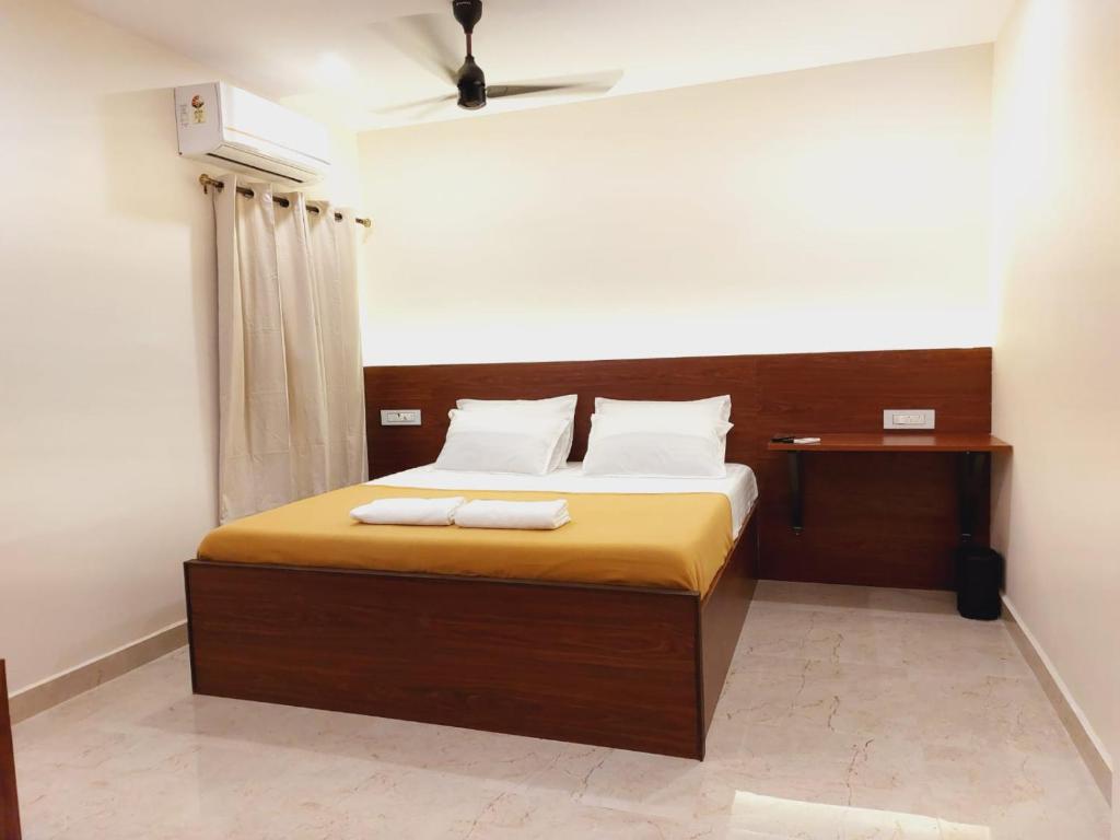 a bedroom with a bed with two towels on it at Chippy Residency in Chennai