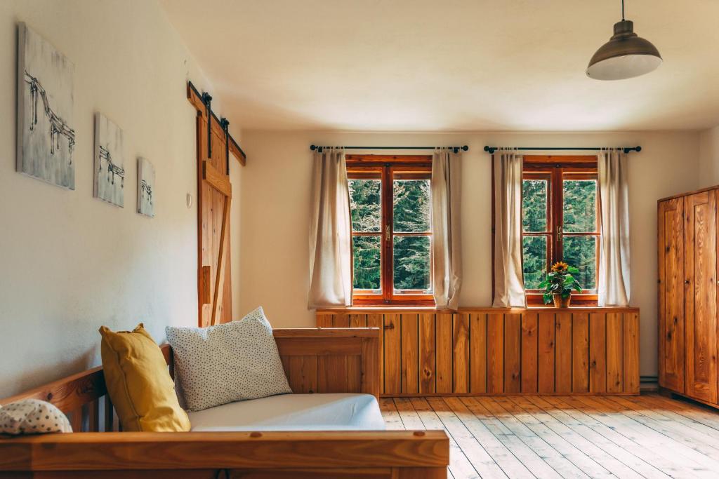 a living room with a couch and two windows at Villa Šumik- Peaceful Hideaway in Ruše