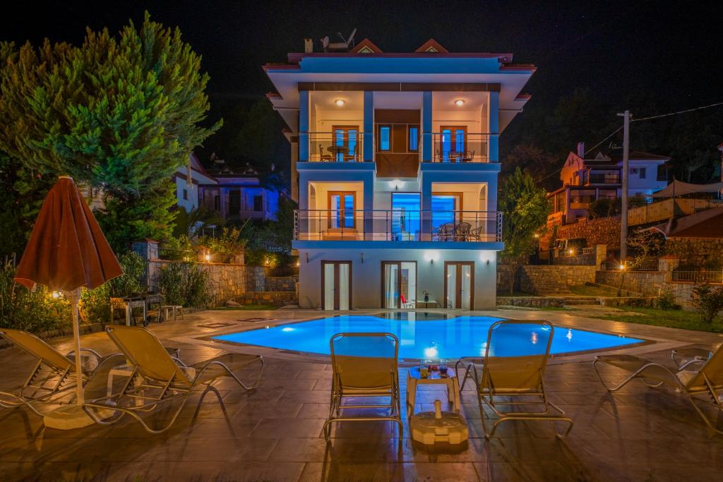 a villa with a swimming pool at night at Infinity Olympia Villas in Oludeniz