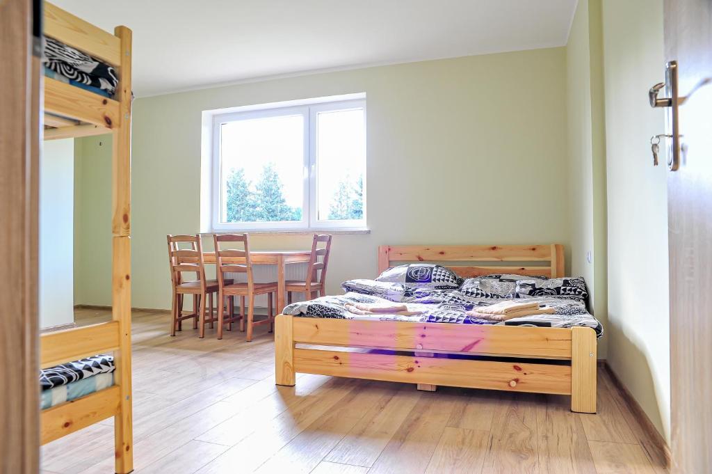 sypialnia z łóżkiem, stołem i krzesłami w obiekcie Farma Serock w Serocku