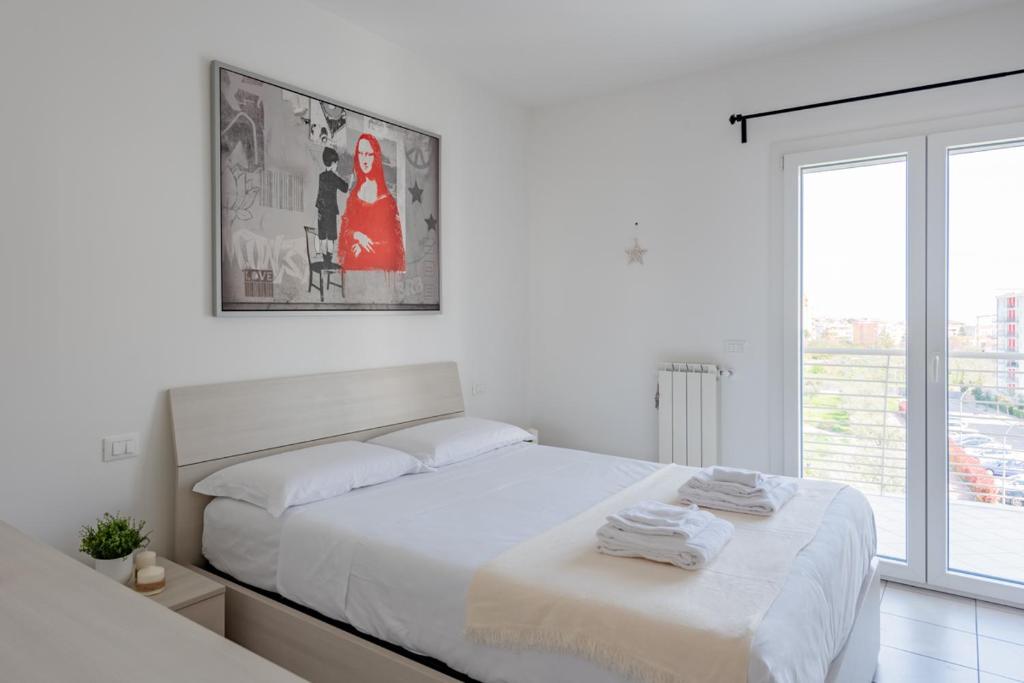 een witte slaapkamer met een bed en een raam bij Spataro4 - YourPlace Abruzzo in Lanciano