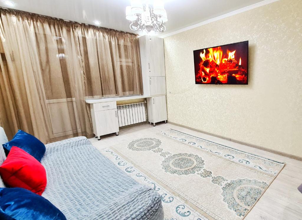 sala de estar con sofá y chimenea en Абсолютно новая квартира класса ЛЮКС, en Taraz