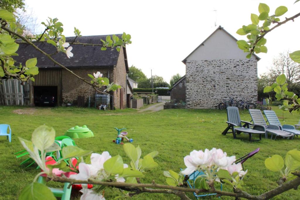 un patio con sillas y un edificio de fondo en La lavandiere, en La Chapelle-au-Riboul