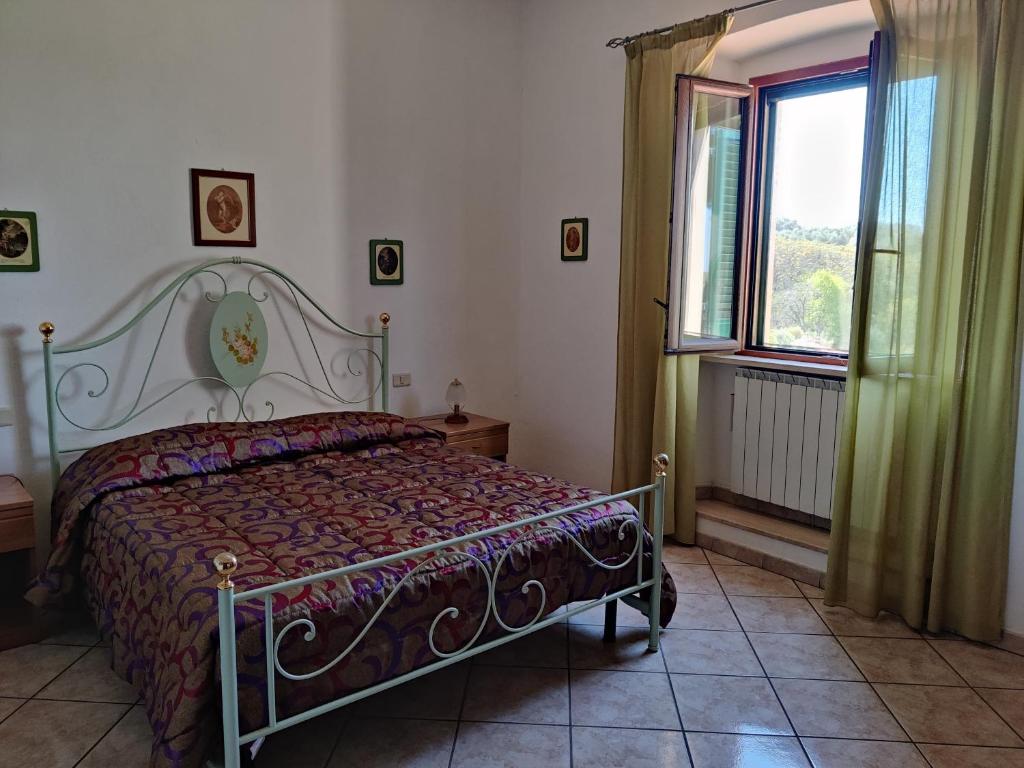een slaapkamer met een bed en een raam bij Affittacamere La Rondinella in Montemerano