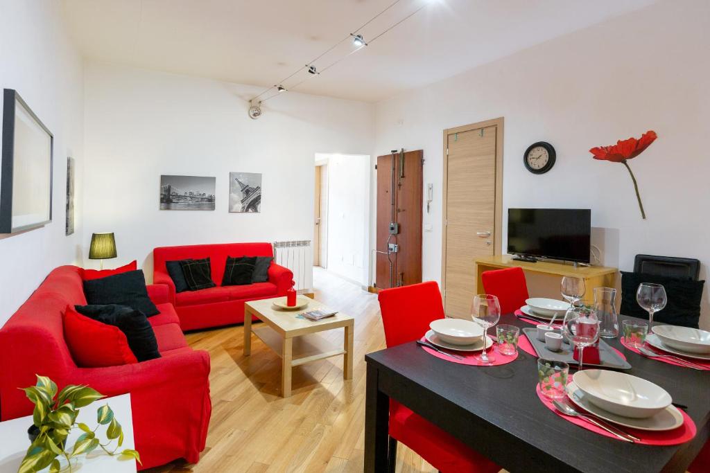 a living room with red chairs and a table at Piazza delle Vettovaglie Historic Center Eco Flat in Pisa