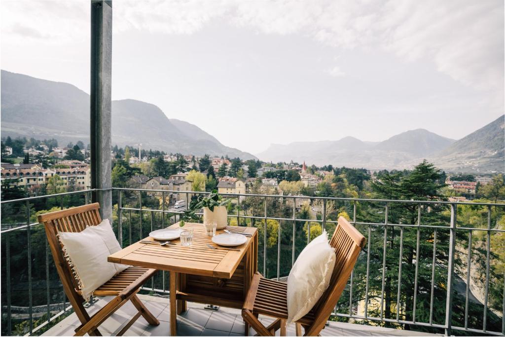 a table and chairs on a balcony with a view at meralino boutique apartment in Merano