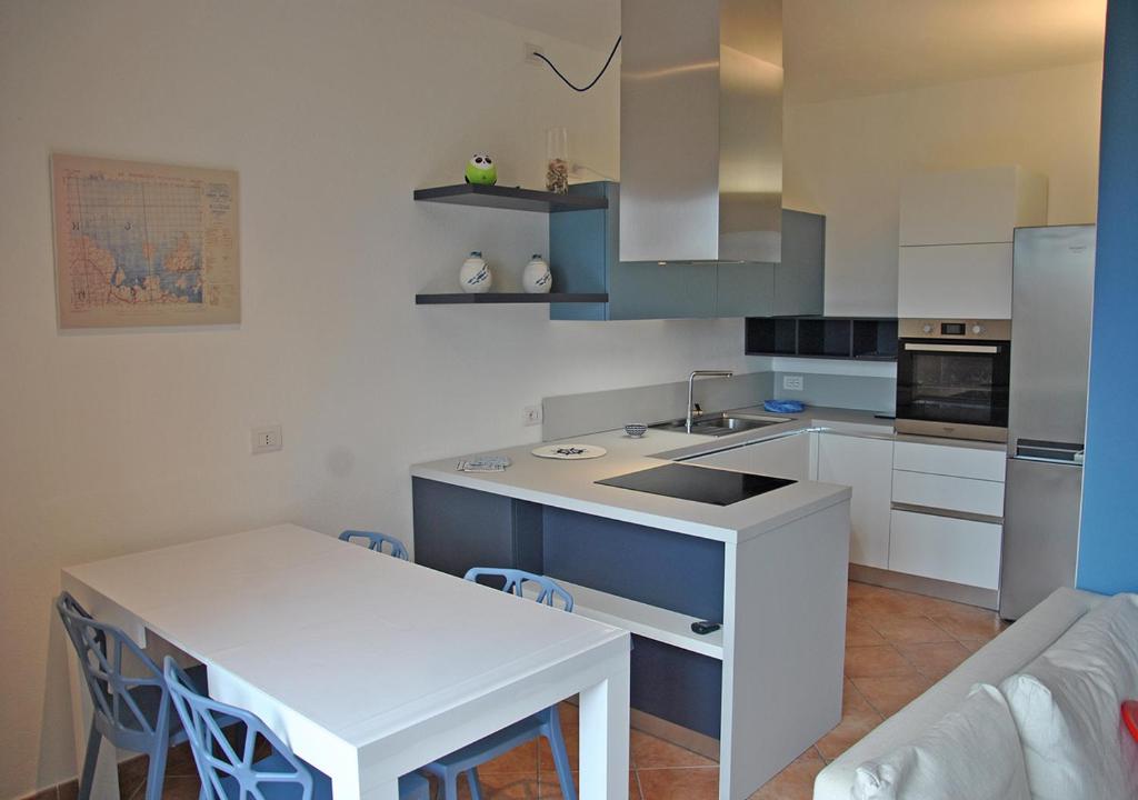 een keuken met een tafel en een wit aanrecht bij Gallura 2 in La Maddalena