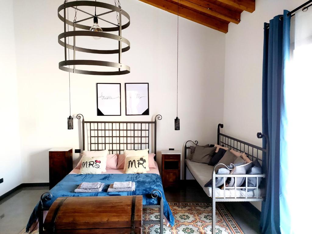 um quarto com uma cama e um lustre em Appartamento Porto Marina S G 2 em Licata