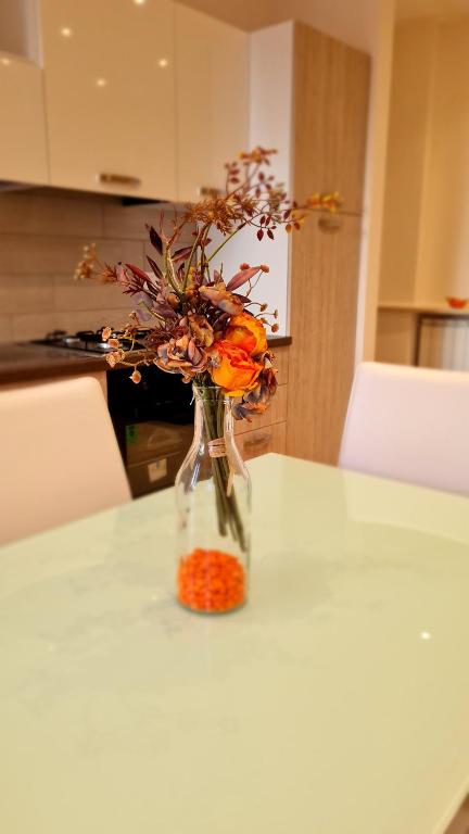 un vase rempli de fleurs orange sur une table dans l'établissement casa Stella centro Foce, à Sanremo