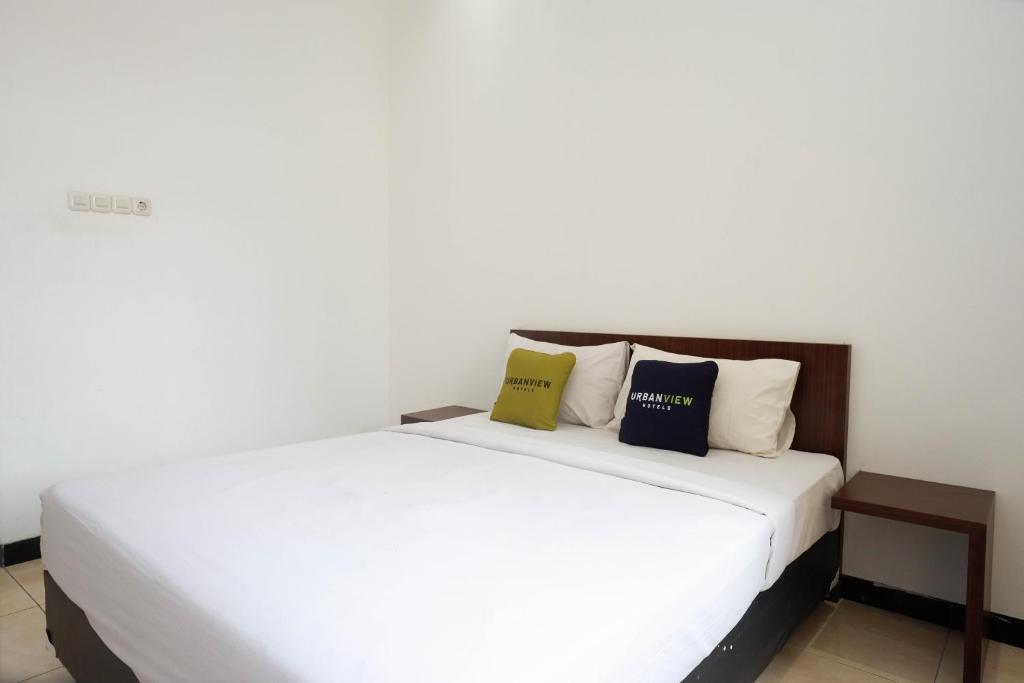 Postel nebo postele na pokoji v ubytování Urbanview Hotel Artama Simpang Lima by RedDoorz
