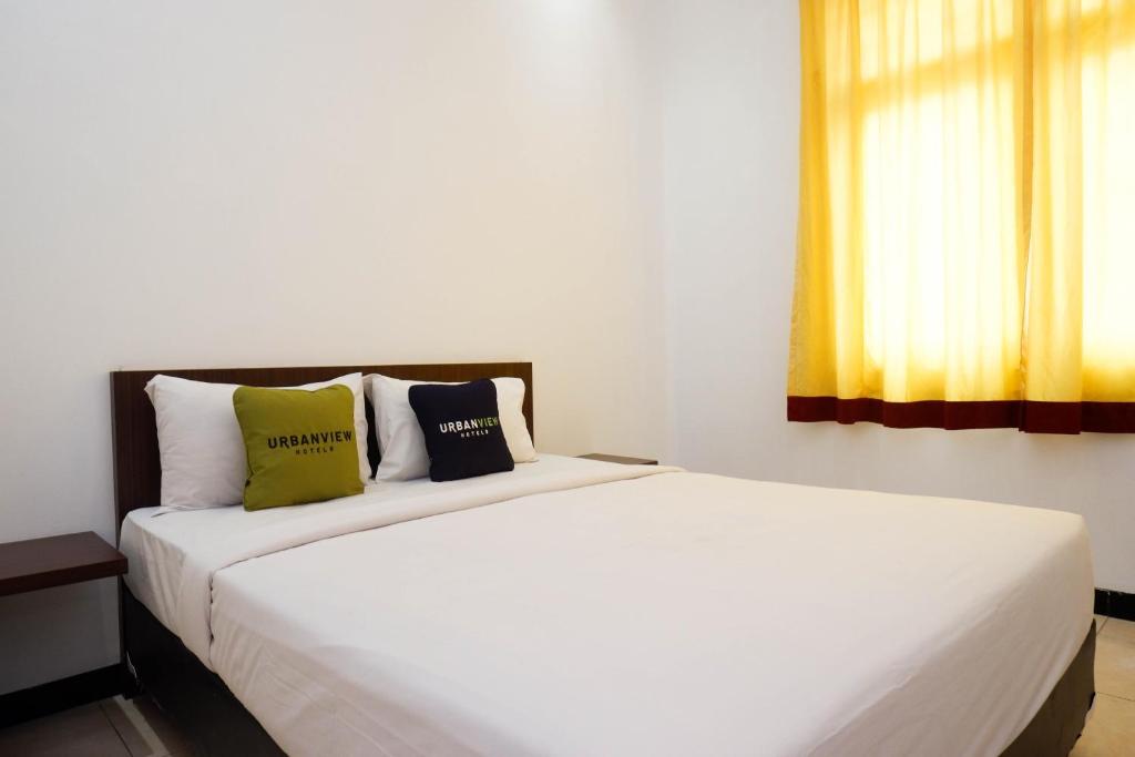 Postel nebo postele na pokoji v ubytování Urbanview Hotel Artama Simpang Lima by RedDoorz