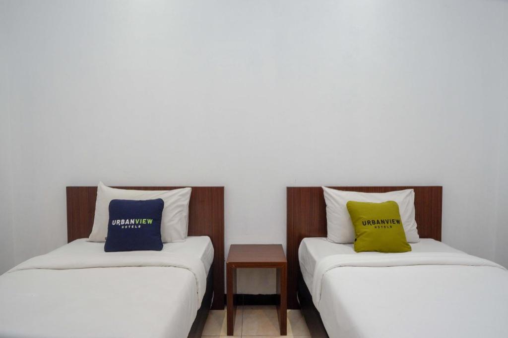 Postel nebo postele na pokoji v ubytování Urbanview Hotel Artama Simpang Lima by RedDoorz
