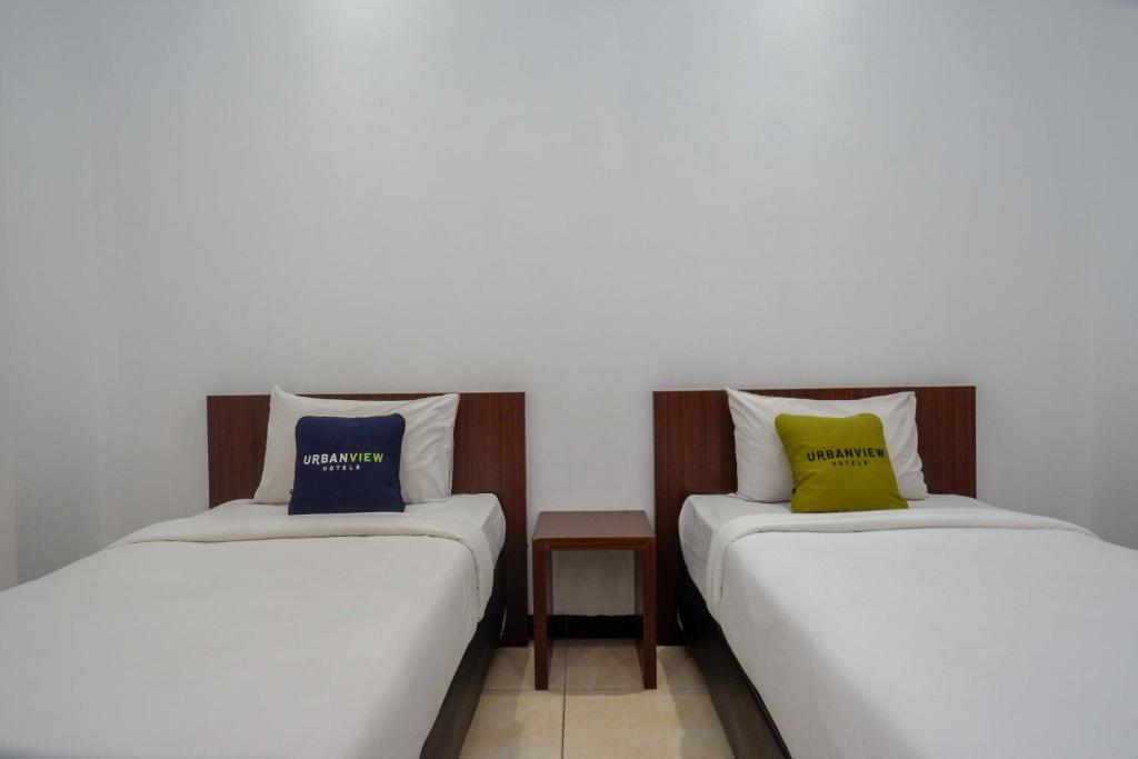 Een bed of bedden in een kamer bij Urbanview Hotel Artama Simpang Lima by RedDoorz