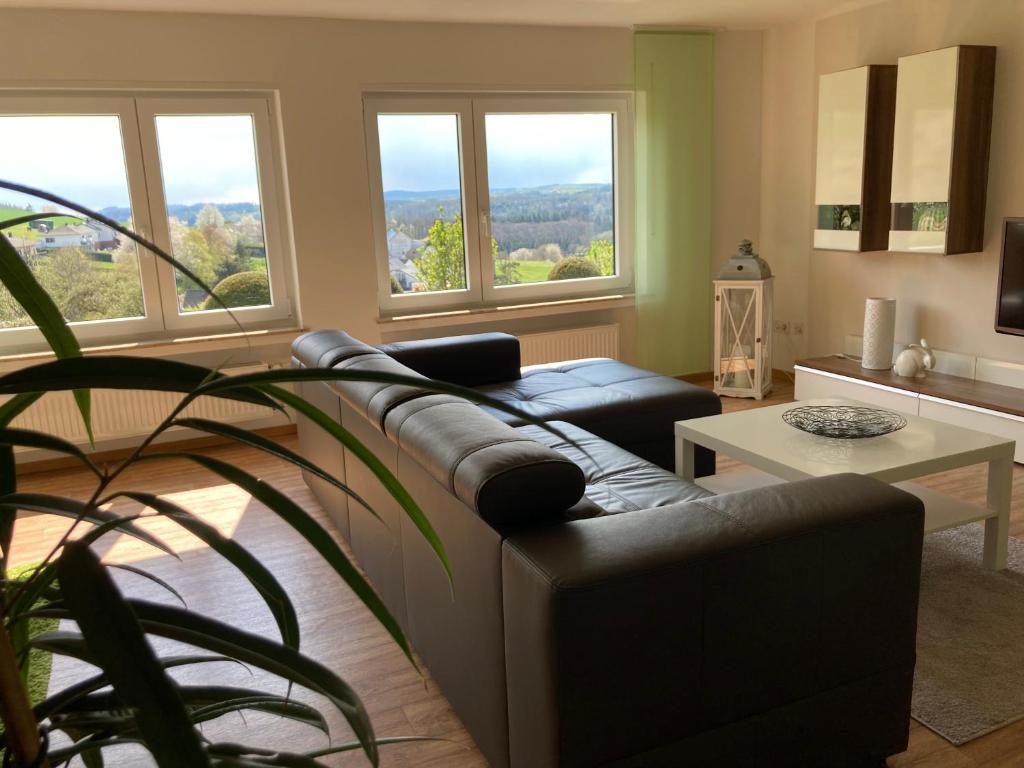 a living room with a couch and a table at Fewo Vulkaneifel in Tettscheid