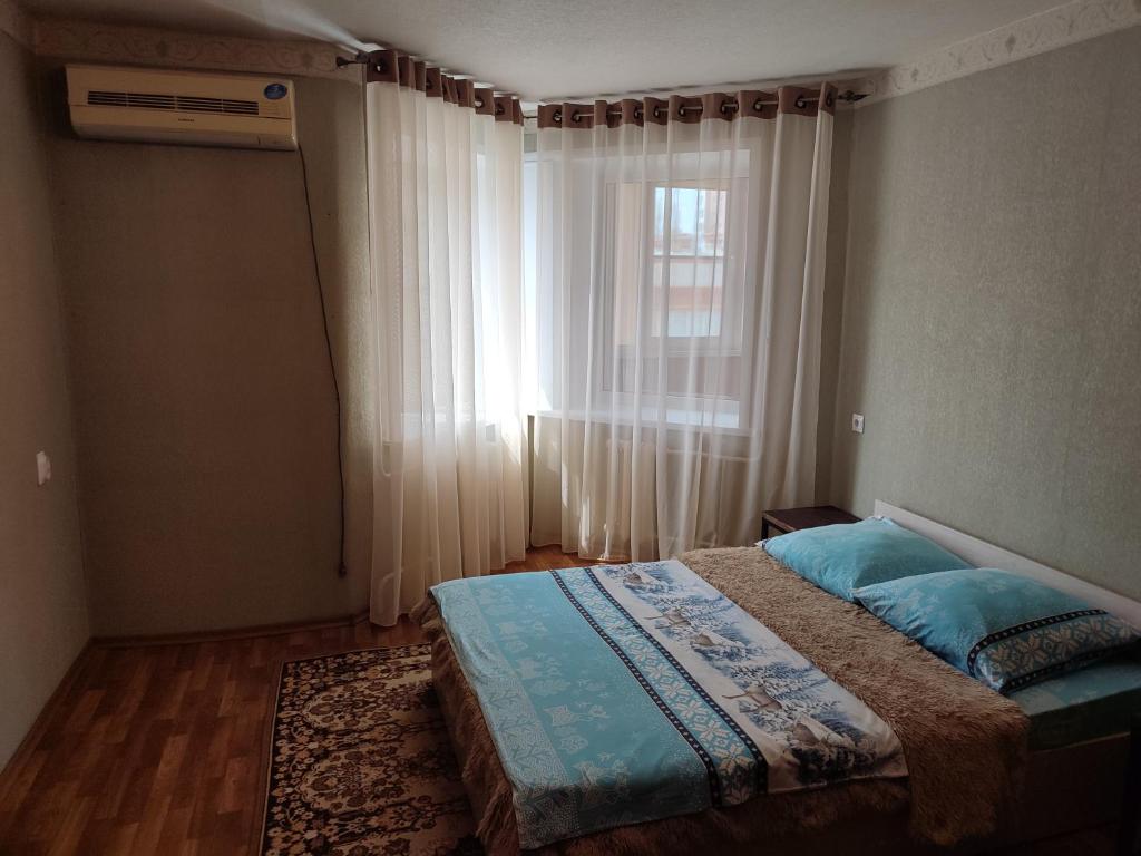 タンボフにあるApartment PrezentHaus Karla Marksa 175aのベッドルーム1室(窓の前にベッド1台付)
