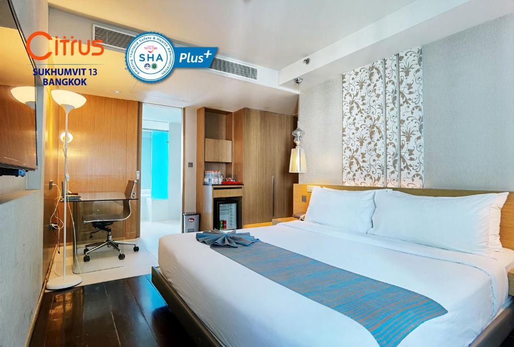 um quarto de hotel com uma cama grande e uma secretária em Citrus Sukhumvit 13 Nana Bangkok by Compass Hospitality em Banguecoque