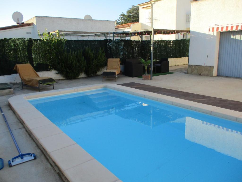 a large blue swimming pool in a backyard at Casa con piscina privada en barrio tranquilo in Castelló d'Empúries