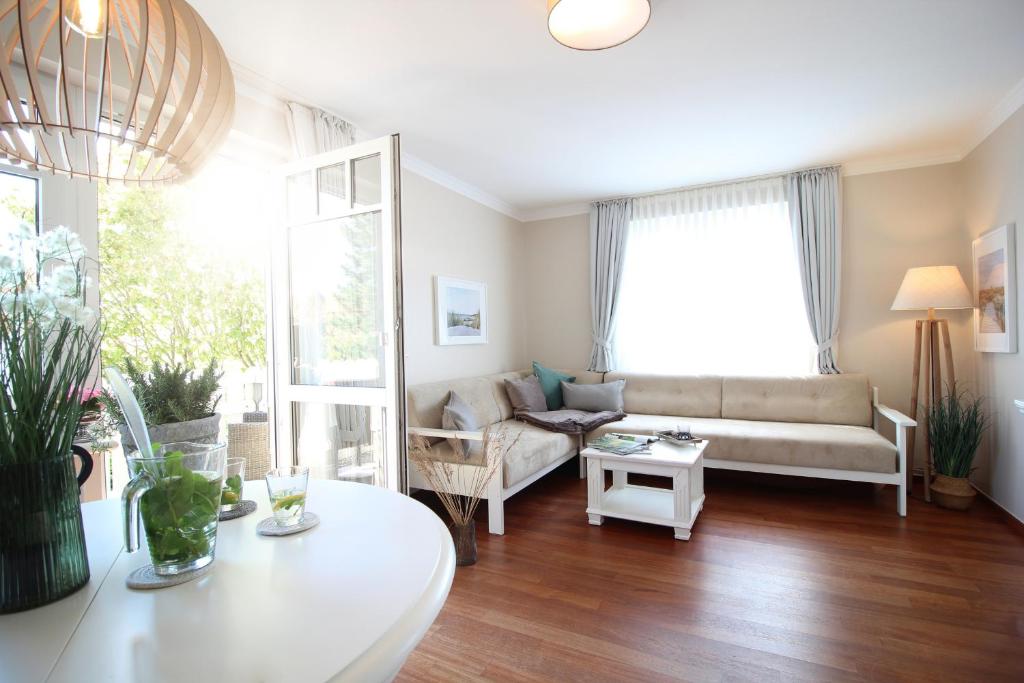 - un salon avec un canapé et une table dans l'établissement Haus am Park Wohnung Nr9, à Spiekeroog