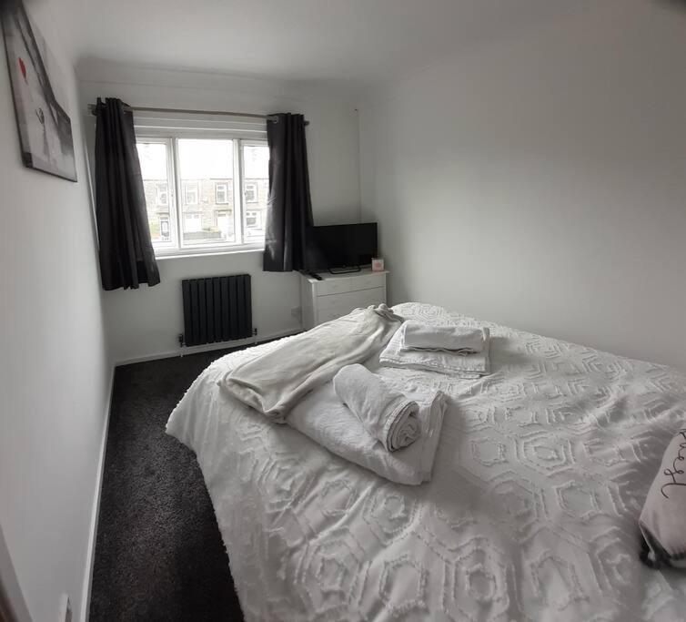 a bedroom with a white bed with towels on it at Alexandra place Skipton child and dog friendly in Skipton