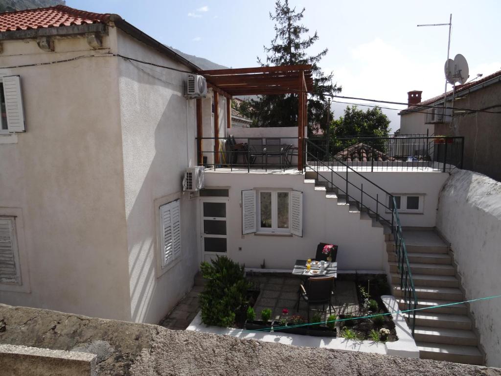 een extern uitzicht op een wit huis met een trap bij Apartments Only in Dubrovnik