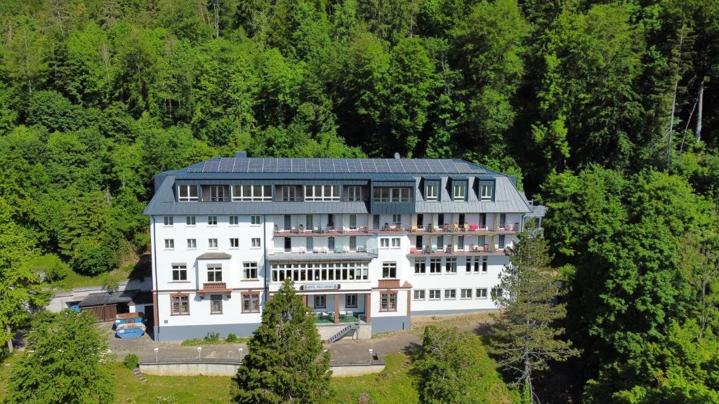 un grand bâtiment blanc avec un toit bleu dans l'établissement Gäste- und Tagungshaus Maria Trost, à Beuron