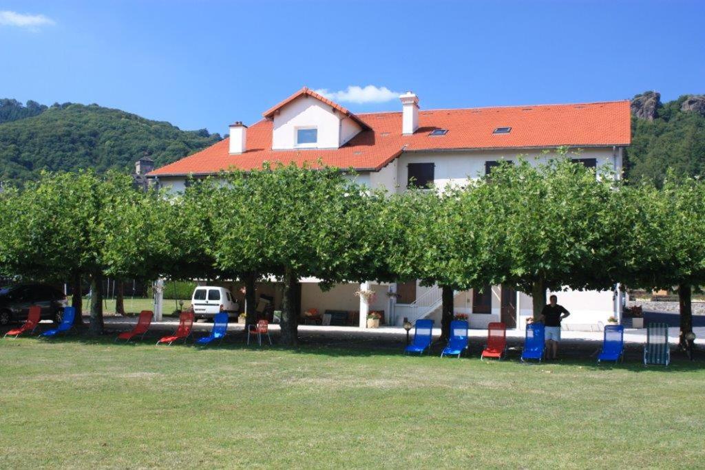 a row of trees and chairs in a park at Le VAL du CANTAL in Polminhac