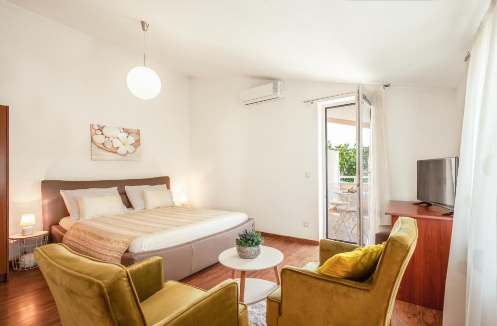 1 dormitorio con 1 cama, mesa y sillas en Apartments Nova Veruda, en Pula
