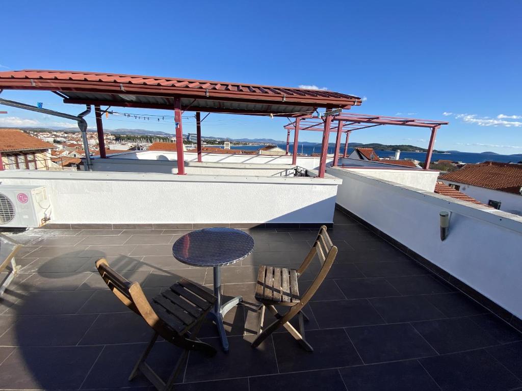 a patio with two chairs and a table on a roof at Enchanting Apartment in Vodice with Sea View Terrace in Vodice