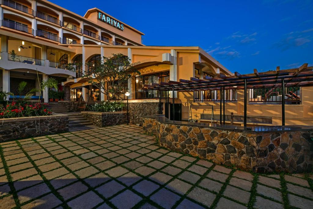 a large stone building with a stone wall at Fariyas Resort Lonavala in Lonavala