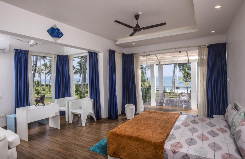 a bedroom with a bed and a table and chairs at Coconut Cove Varkala in Varkala