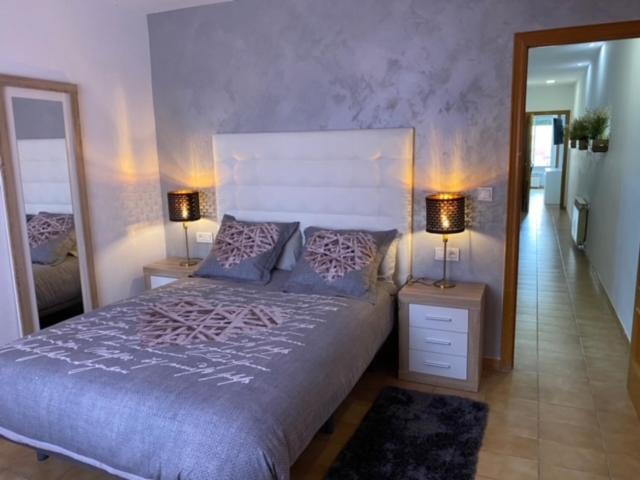 a bedroom with a bed with two lamps and a mirror at Piso céntrico con Parking a 20min de Barcelona in Terrassa