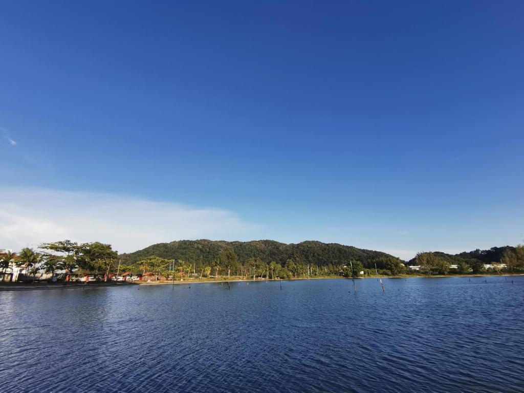 vistas a un lago con árboles a lo lejos en Rustic one bedroom unit for 4 pax with Sea View by JoMy Homestay en Lumut