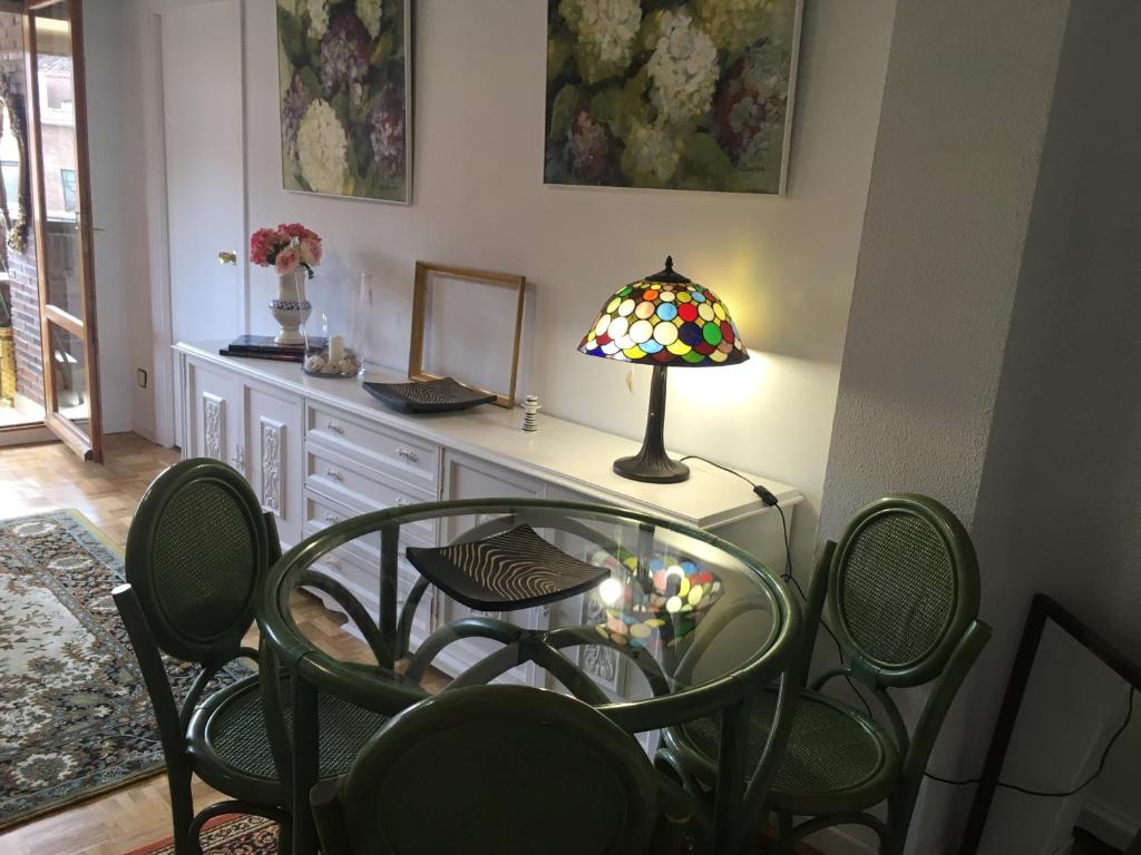 a glass table with chairs and a lamp on it at Saldaña. Apartamento in Saldaña