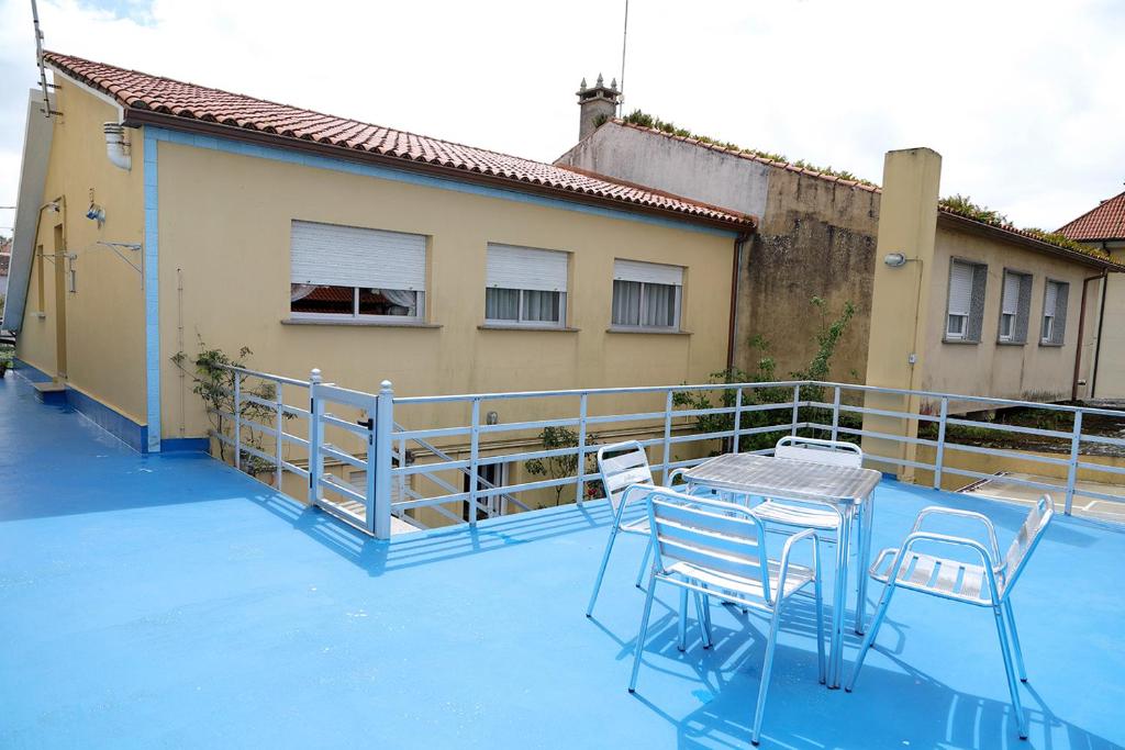 un balcón con mesa y sillas en una planta azul en A Rosaleda, en Vilagarcía de Arousa