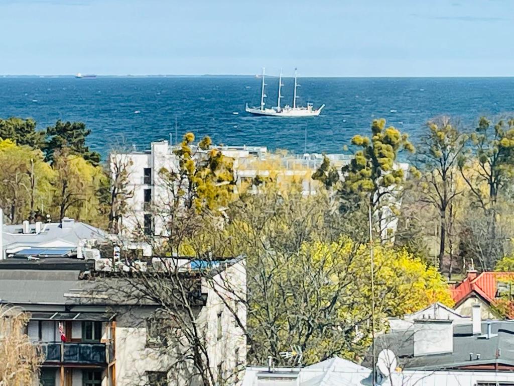 un barco flotando en el agua cerca del océano en Apartament Karlikowska z widokiem na morze en Sopot