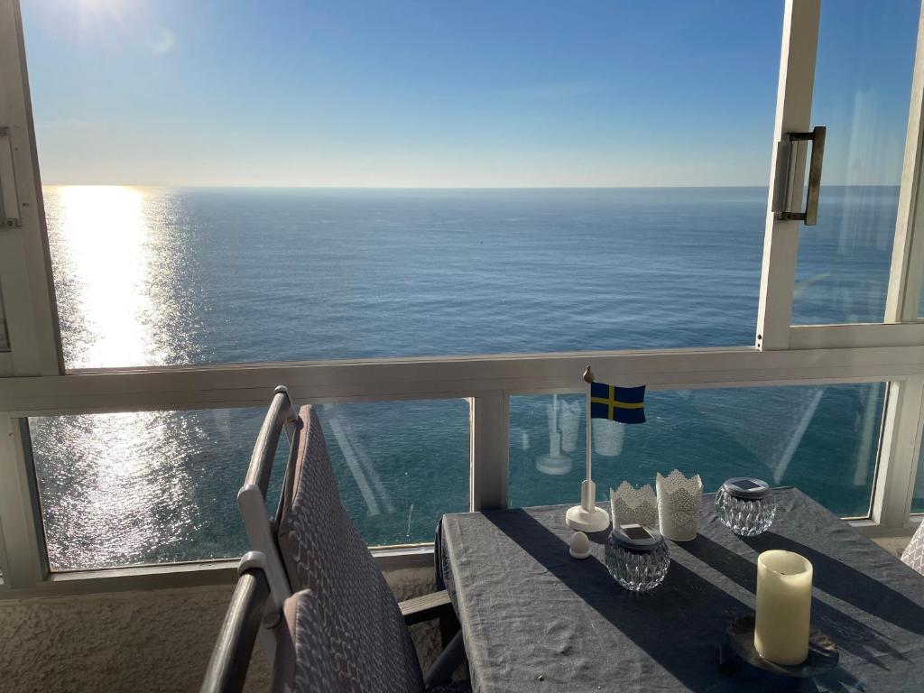 uma mesa numa varanda com vista para o oceano em Ático espectacular en primera línea playa con piscina em Altea