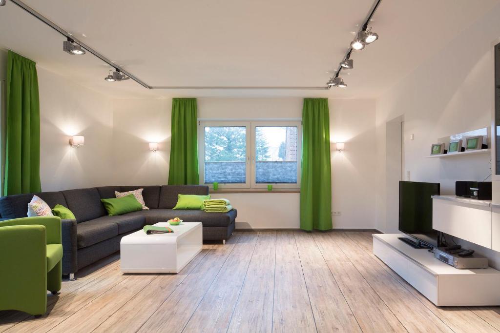 a living room with a couch and a tv at Mienhus Apartments Ferienwohnung Fiete in Norden