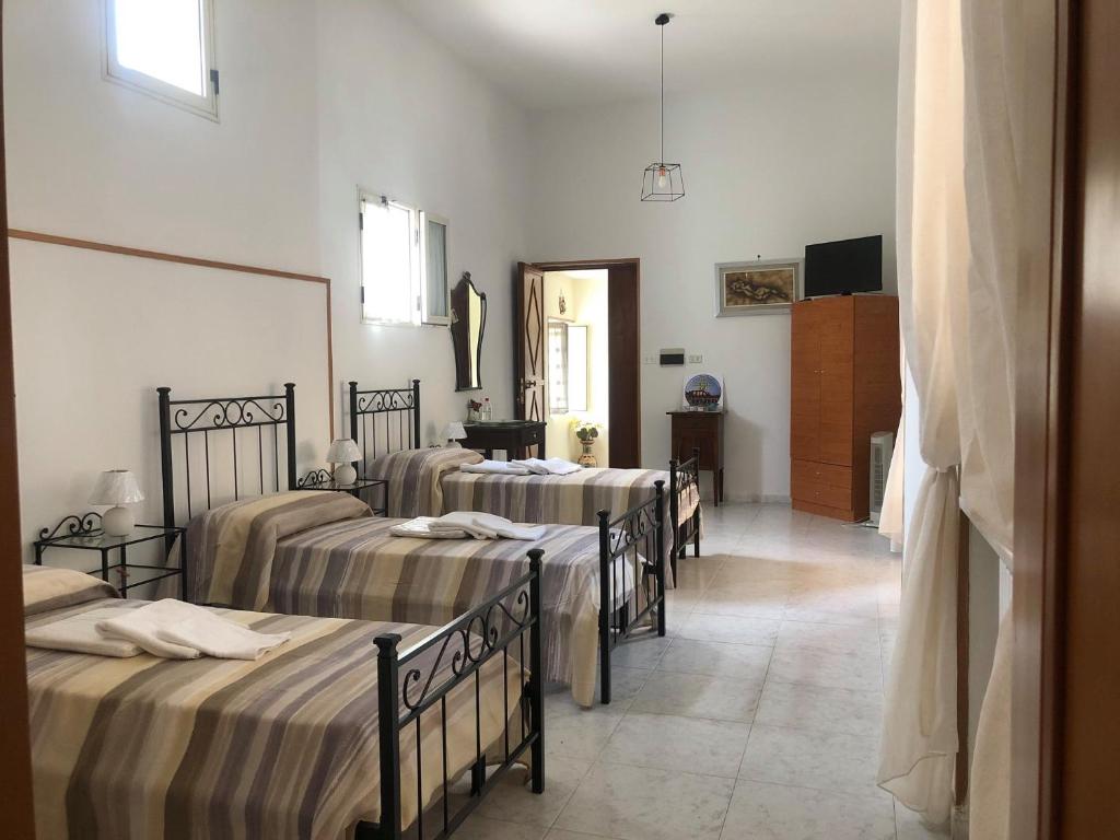 a group of four beds in a room at B&B 43 in Santa Maria Capua Vetere