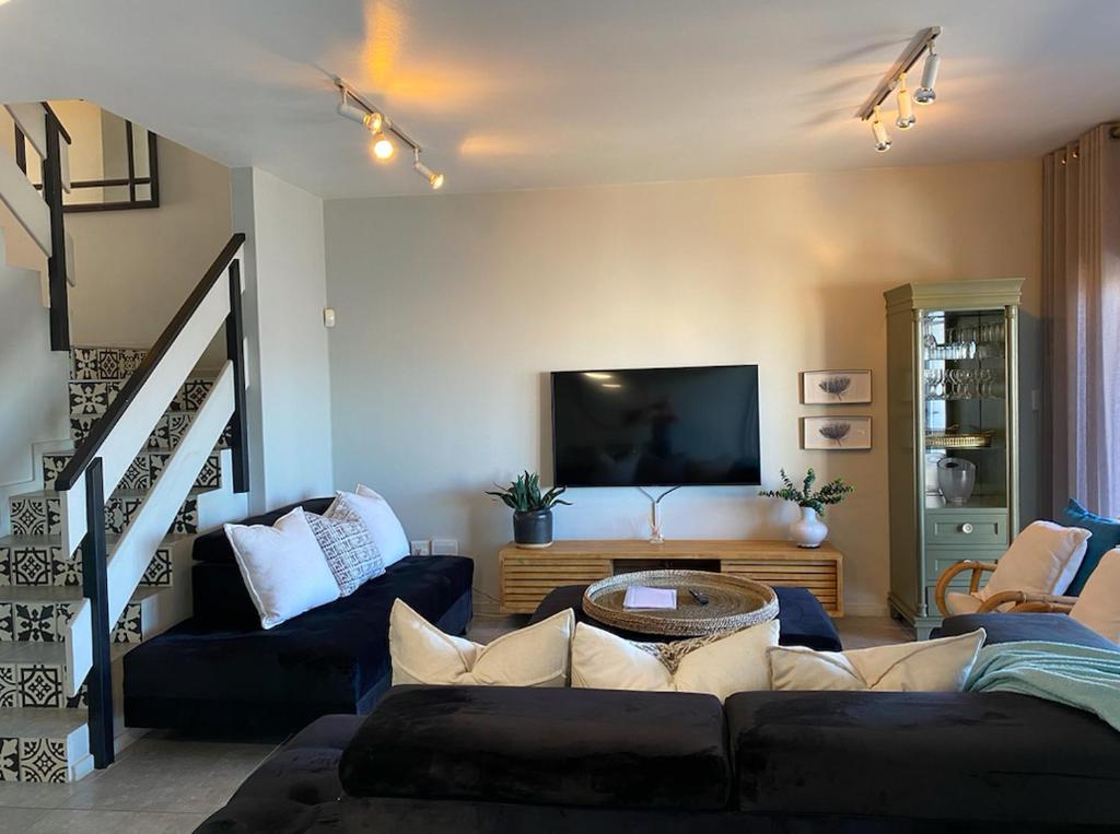 a living room with a couch and a tv at Beach front, two story condo in Ballito
