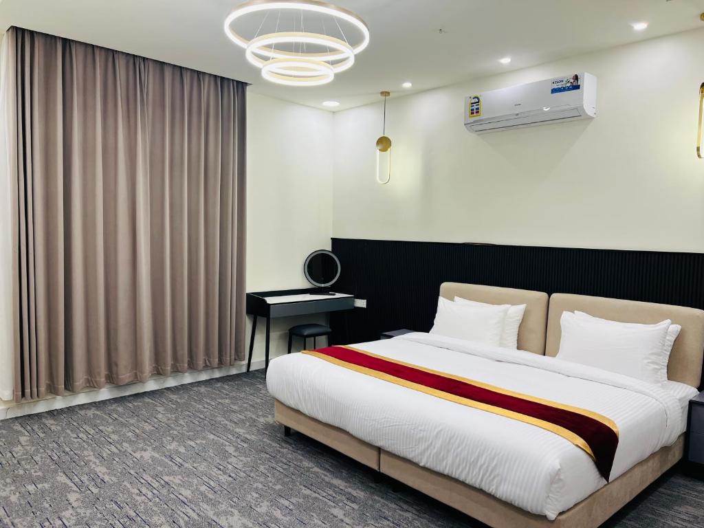 1 dormitorio con 1 cama grande y escritorio en Falcon Grand Hotel, en Al Hadd