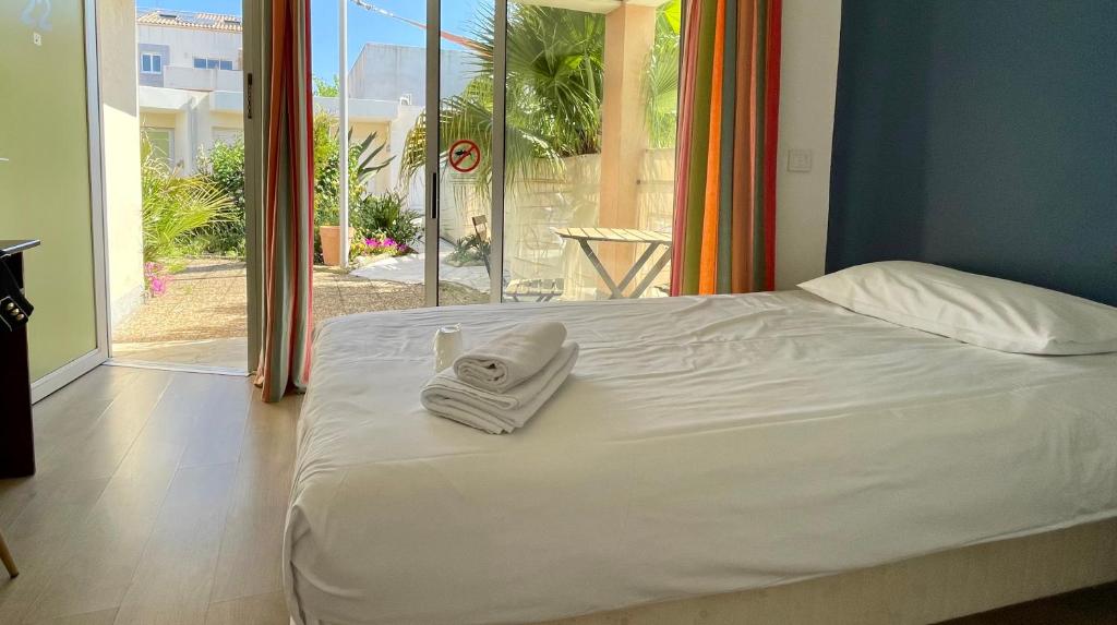 Postel nebo postele na pokoji v ubytování Amerique Hotel Palavas - Piscine - Plage