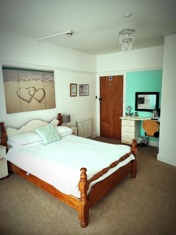 a bedroom with a large bed and a desk at St Breca in Newquay