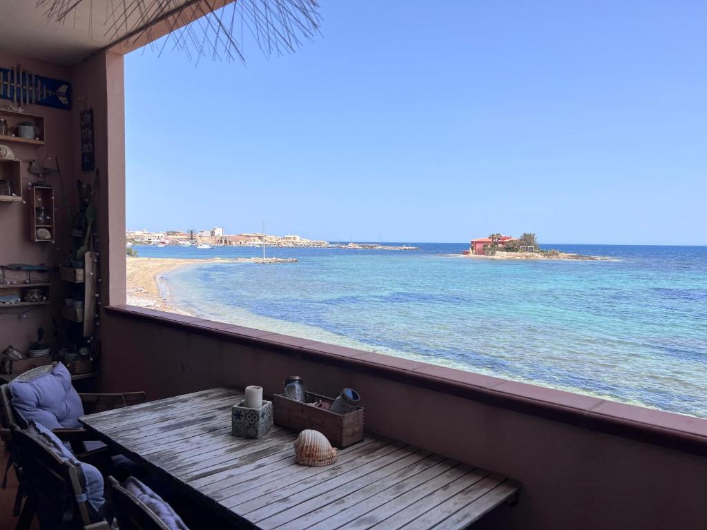 a table on a balcony with a view of the beach at La casa dell'Alba in Marzamemi