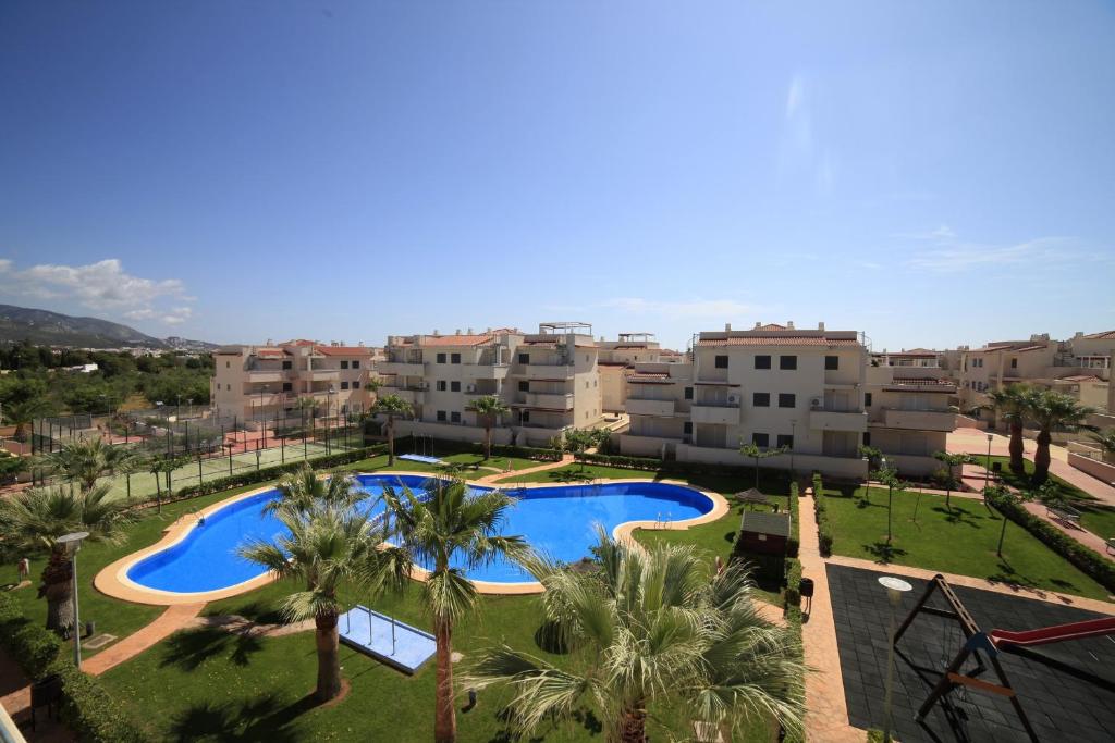 Vistas al árido de un complejo de apartamentos con piscina y palmeras en Apartamentos Arenas Altamar, en Alcossebre