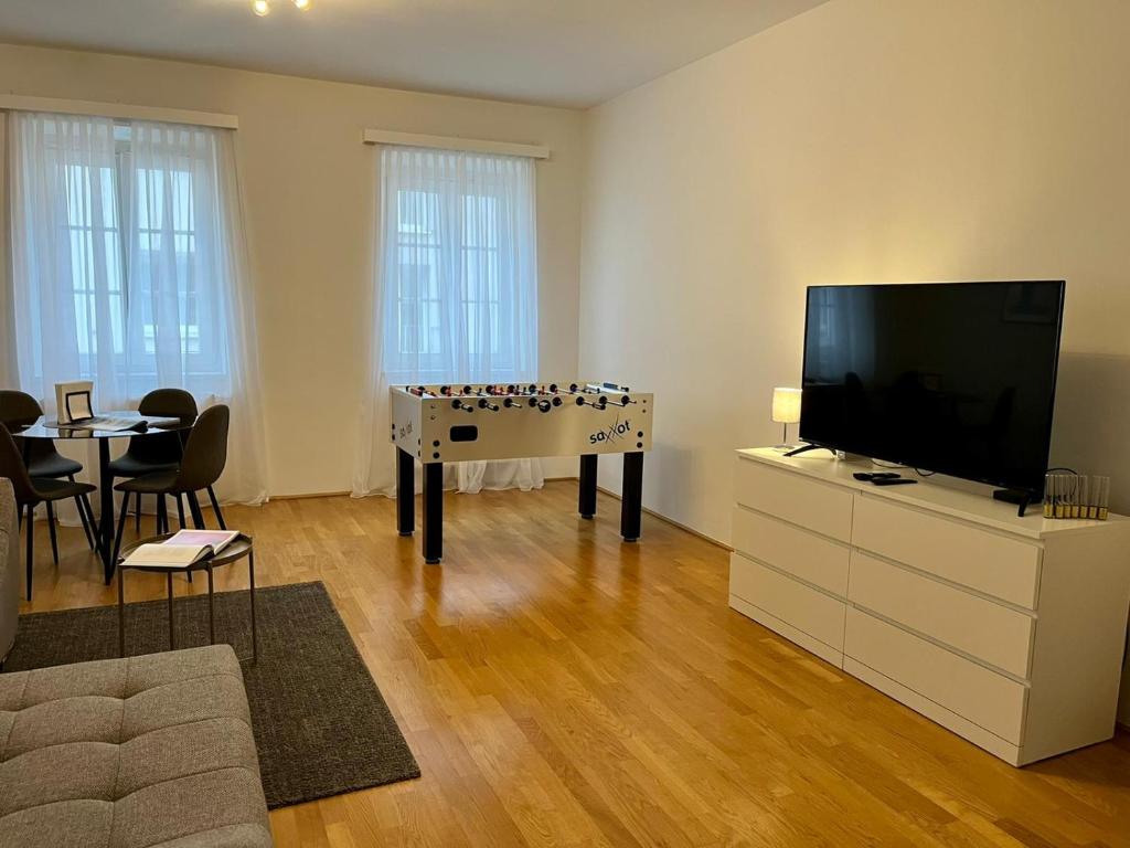 uma sala de estar com televisão e uma mesa com xadrez em Vienna City Apartments Krongasse em Viena