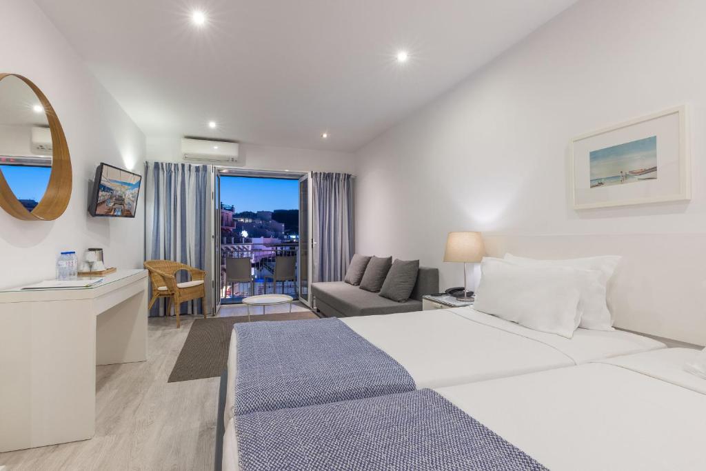 a white bedroom with a large bed and a living room at Hotel Baltum in Albufeira