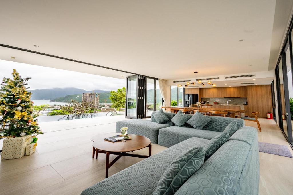 芽莊的住宿－La Nha Trang Villa by Elite Stay，客厅配有蓝色的沙发和圣诞树
